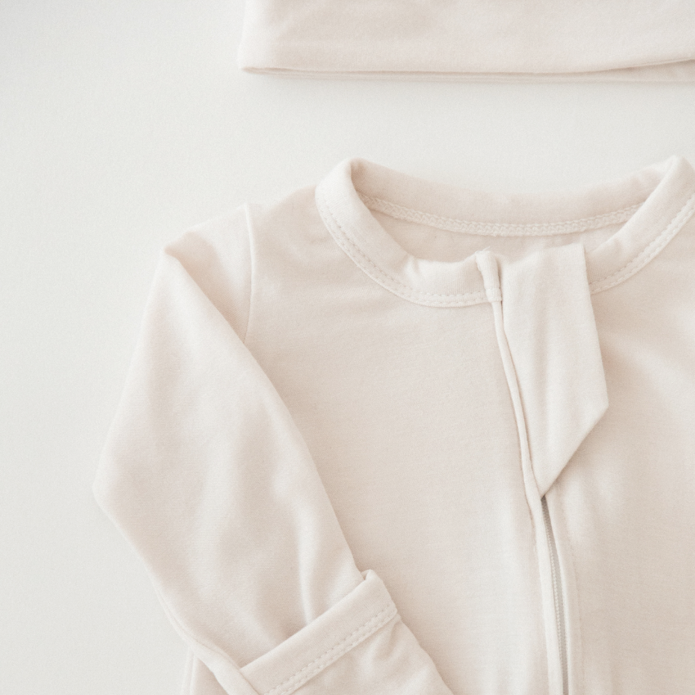 Close up of a neutral Milana Label sleeper for babies.