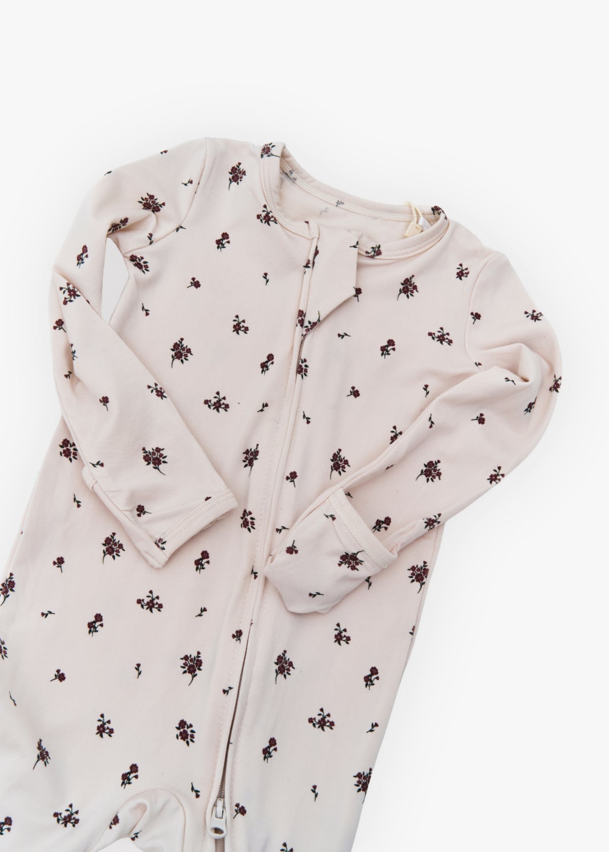 Milana Label kids zip footie sleeper in Birch Floral, a warm neutral fabric with a scattered dark floral print, with grip dots on the feet.