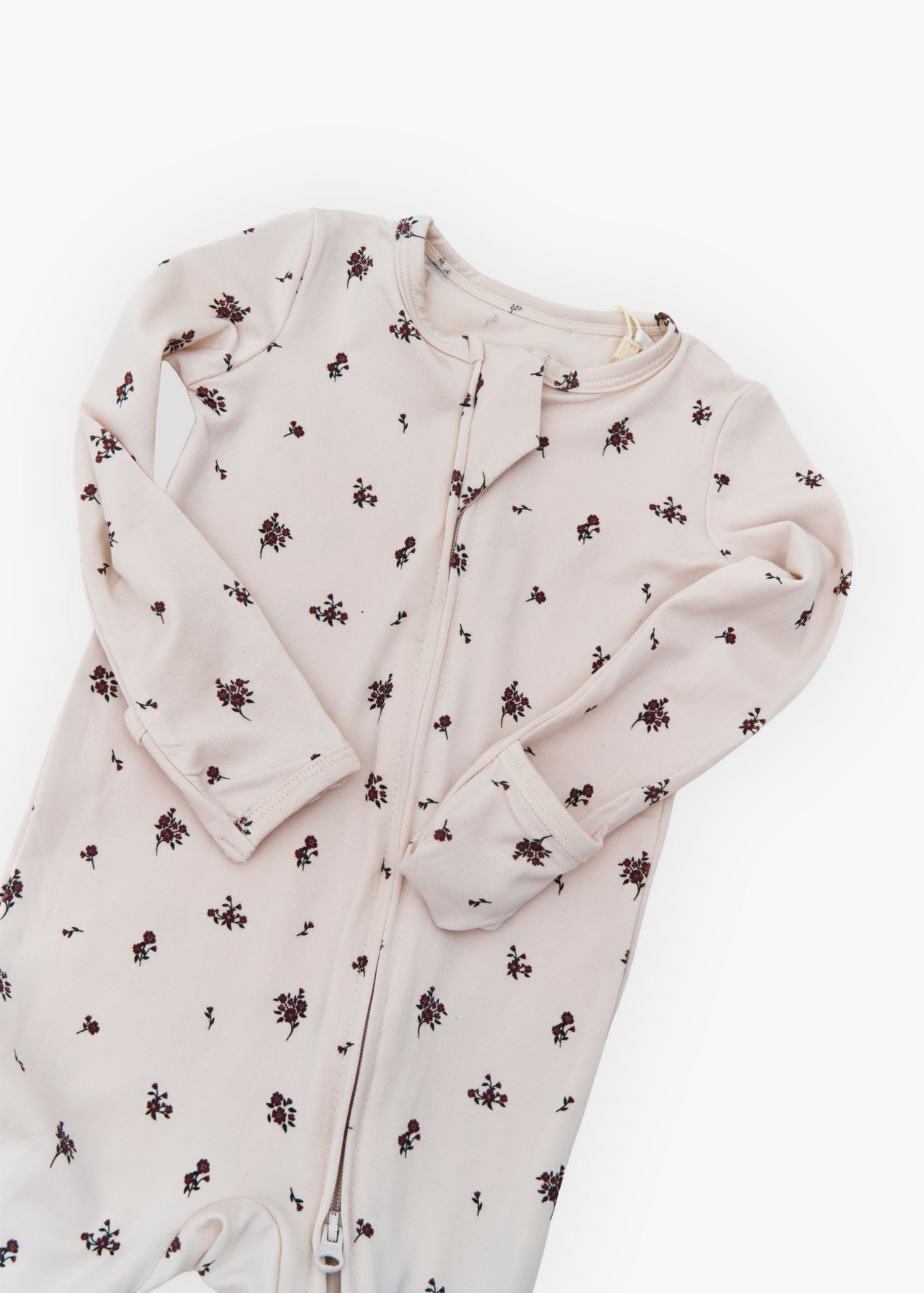Milana Label kids zip footie sleeper in Birch Floral, a warm neutral fabric with a scattered dark floral print, with grip dots on the feet.