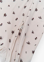 Milana Label kids zip footie sleeper in Birch Floral, a warm neutral fabric with a scattered dark floral print, with grip dots on the feet.