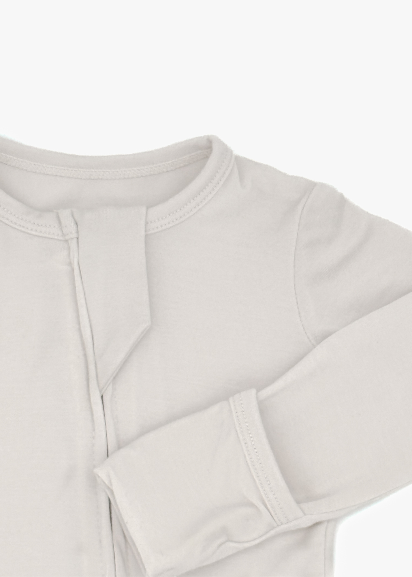 Milana Label Zippered Sleeper in the colour Birch on an off white background. Highlighting the fold-over mitts.