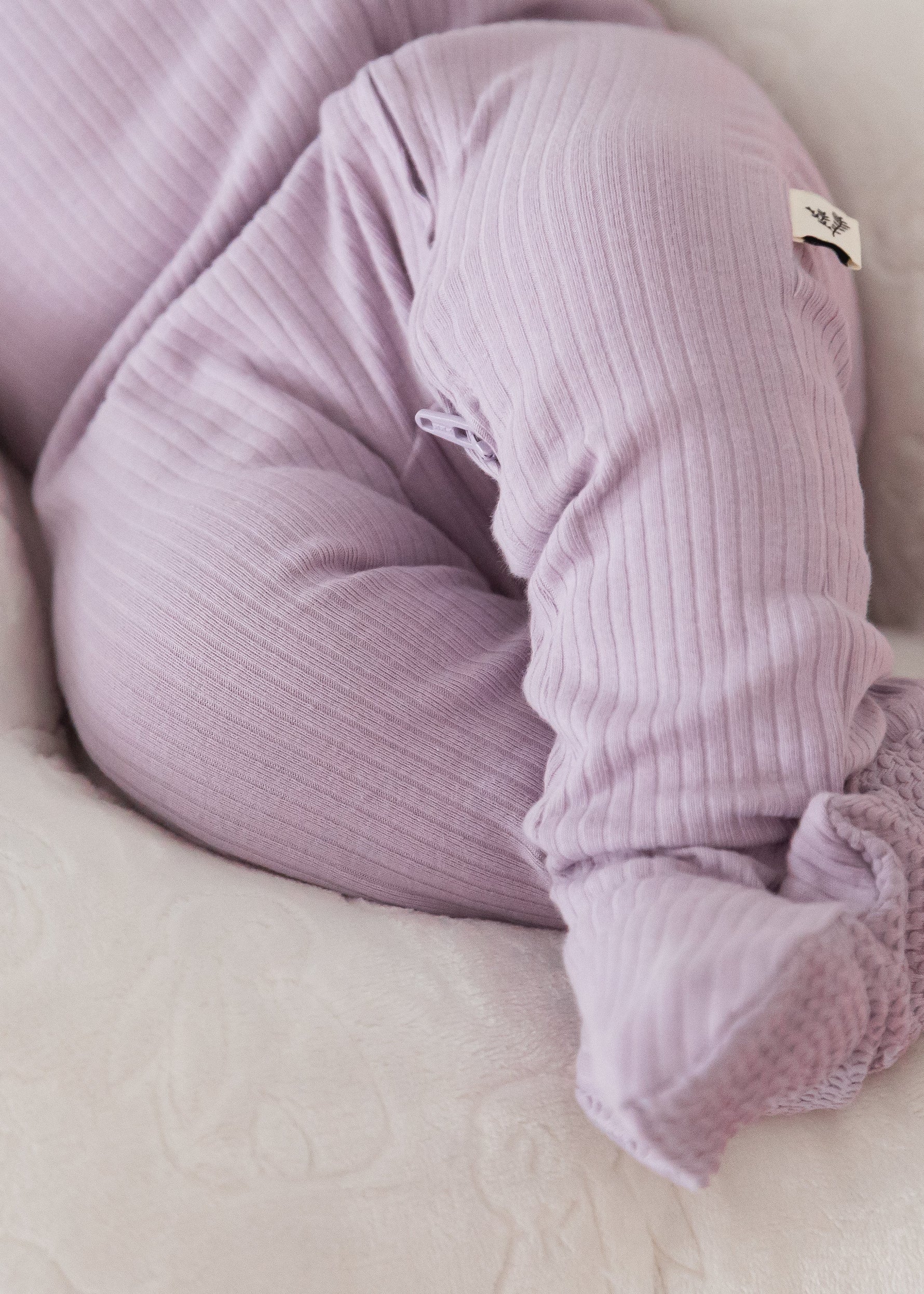 Close-up detail of a baby wearing the Lavender Blush organic cotton footie sleeper, highlighting the soft ribbed fabric and enclosed footies.