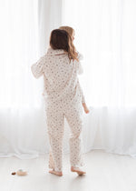 Back view of a mother holding her toddler, both wearing matching Tencel pajamas in a floral print by Milana Soft.