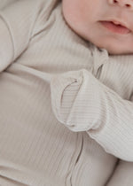 Close-up detail of the fold-over scratch mitts feature on the sleeve of the Milana Label Stone greige ribbed baby sleeper.