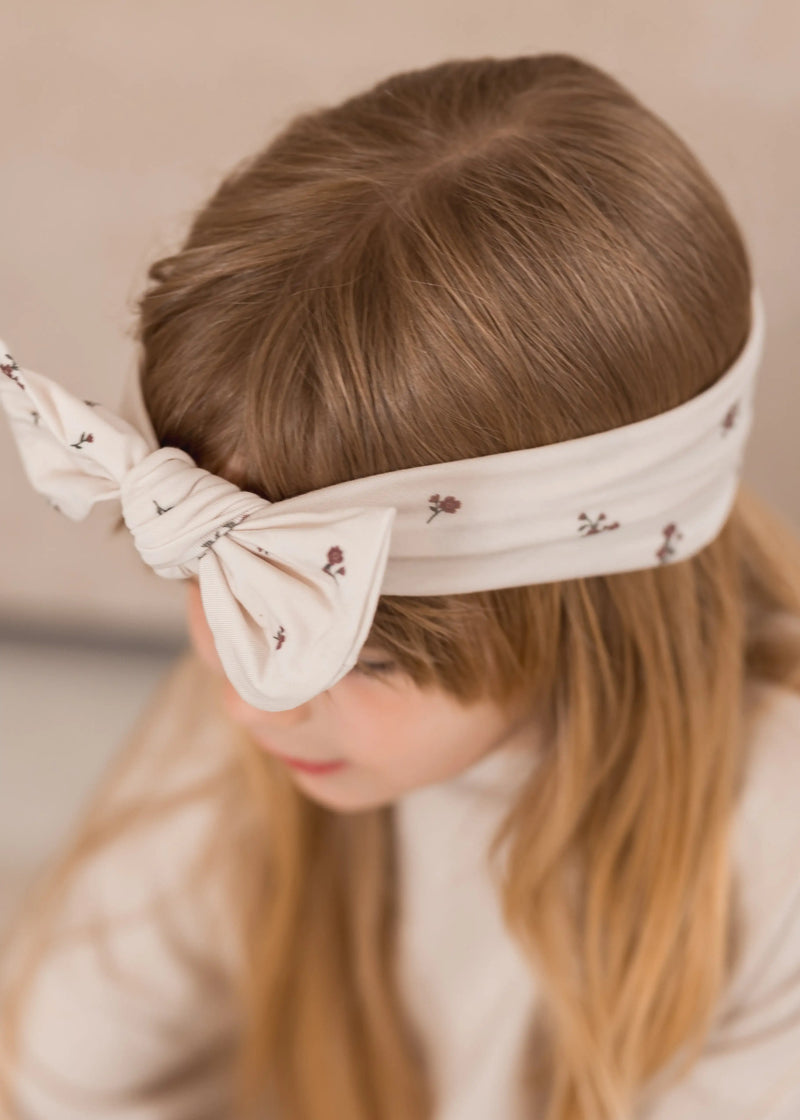 A close-up of our Birch Floral knot headband being worn by a child.