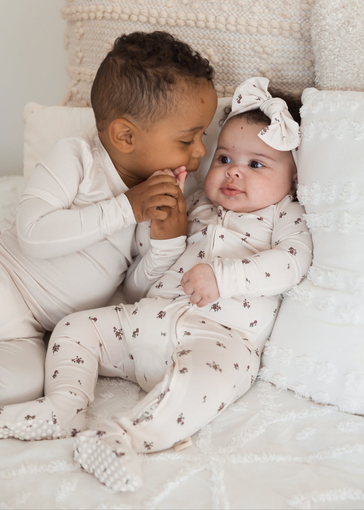 Two siblings lounging in their Milana PJ's with a neutral background.