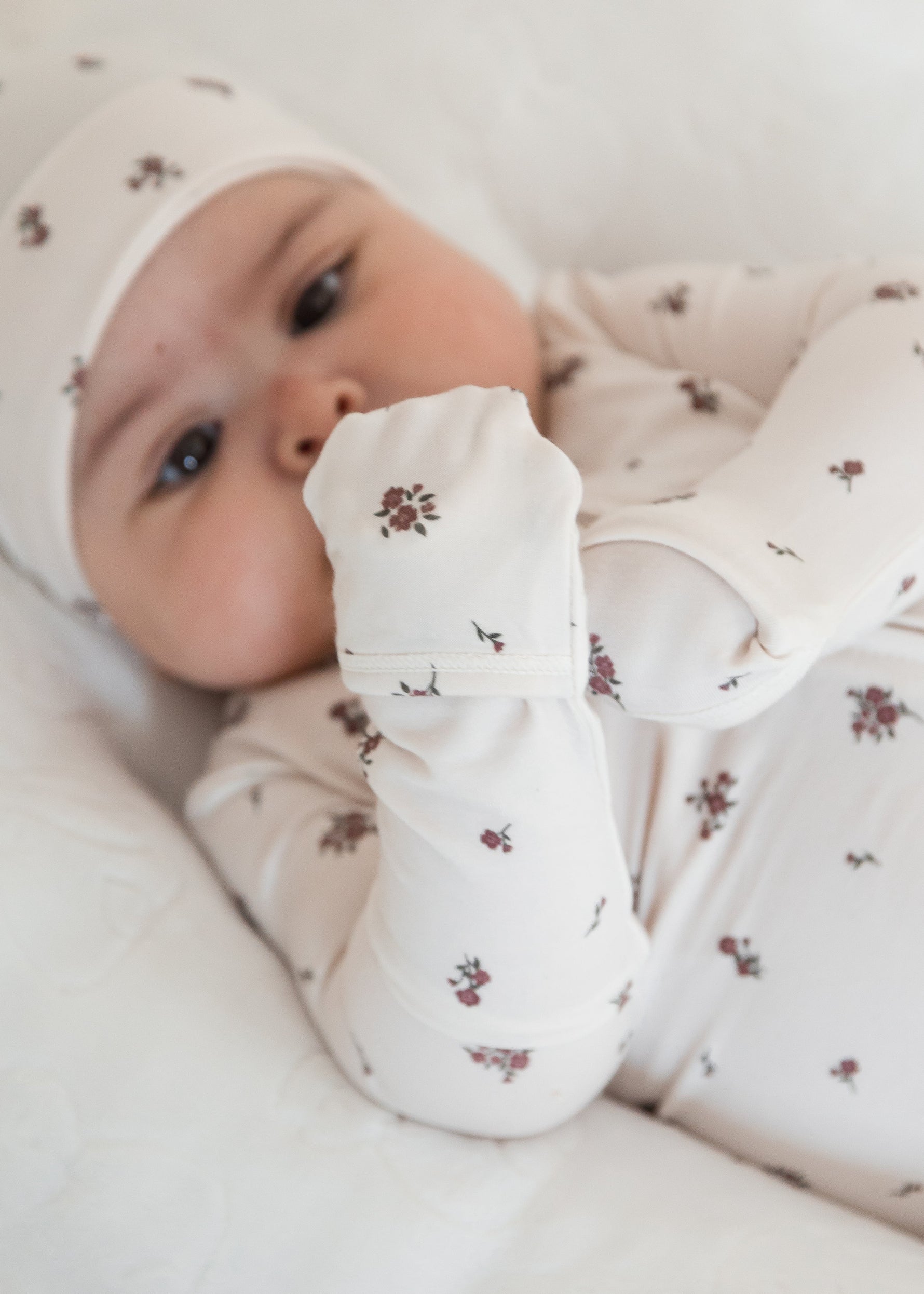 A close up of a Milana Label sleeper in the colour Birch Floral highlighting the fold-over mitts on all sizes. 