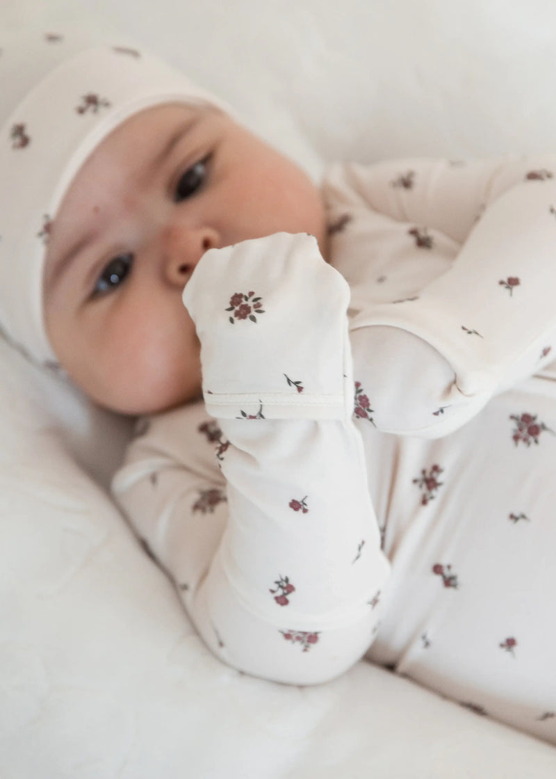 A close up of a Milana Label sleeper in the colour Birch Floral highlighting the fold-over mitts on all sizes. 
