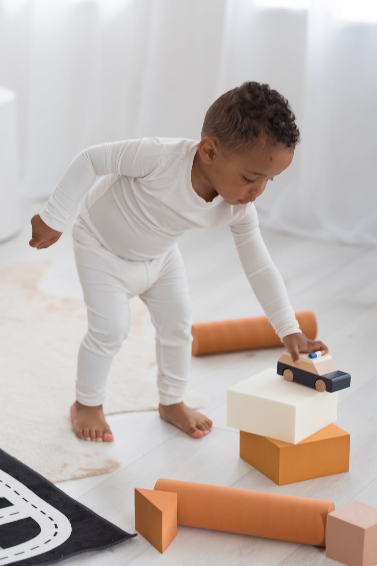 Boy playing on the floor in his neutral Milana Label PJ set.