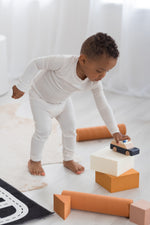 Boy playing on the floor in his neutral Milana Label PJ set.