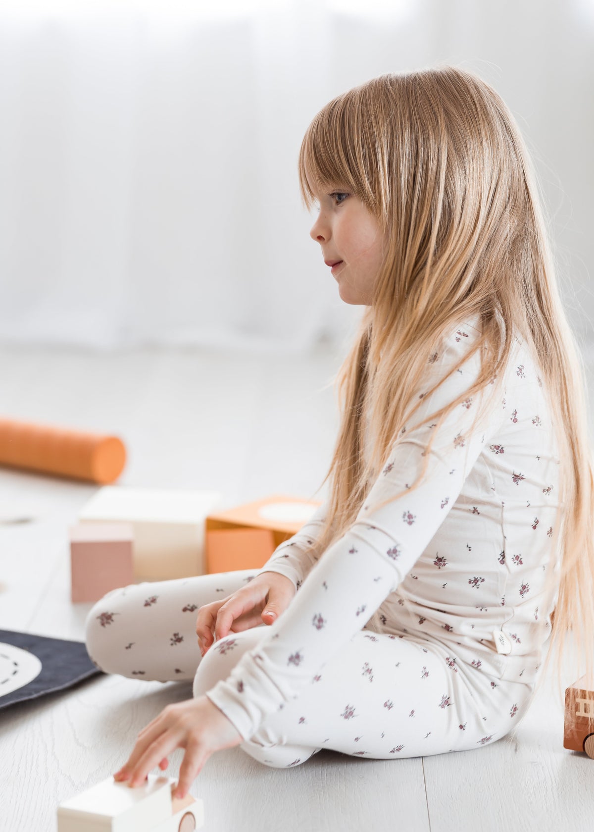 A little girl playing on the floor in her Milana Label PJ set.
