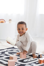 Boy playing on the floor in his neutral Milana Label PJ set.