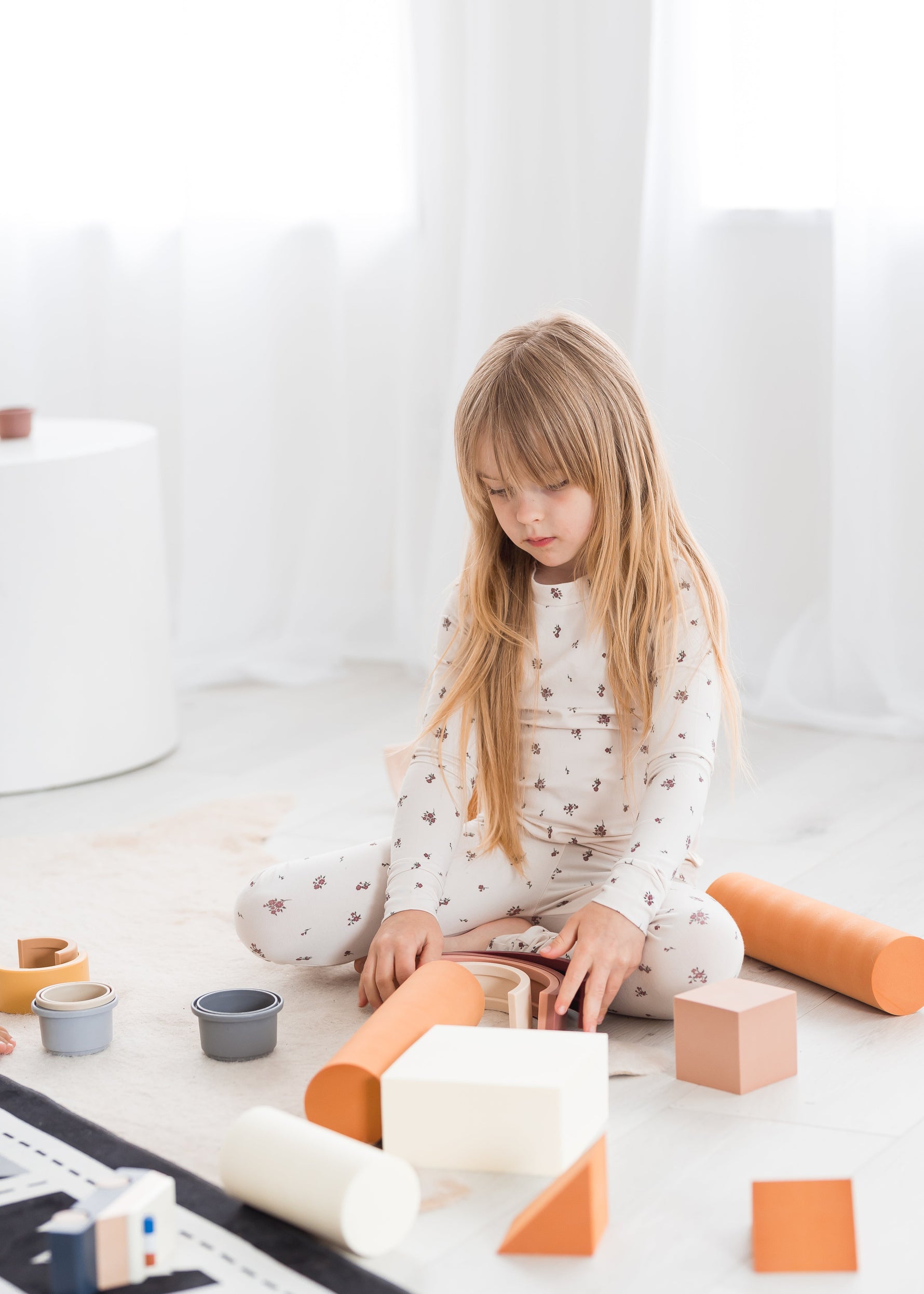 A little girl playing on the floor in her Milana Label PJ set.