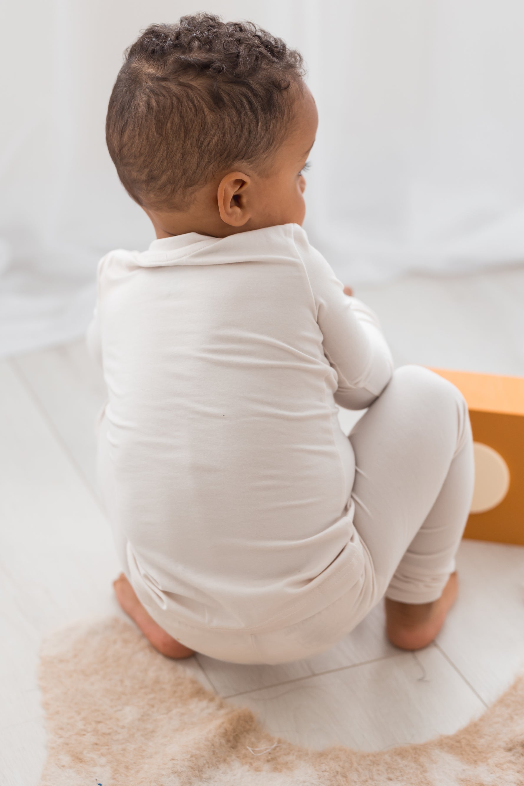 Boy playing on the floor in his neutral Milana Label PJ set.