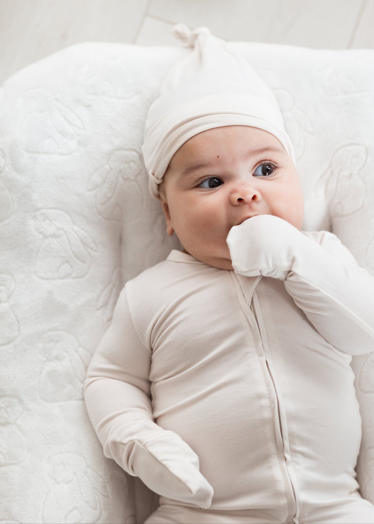 Infant wearing a Milana Label sleeper in the colour Birch, showing the fold-over cuff detail. 