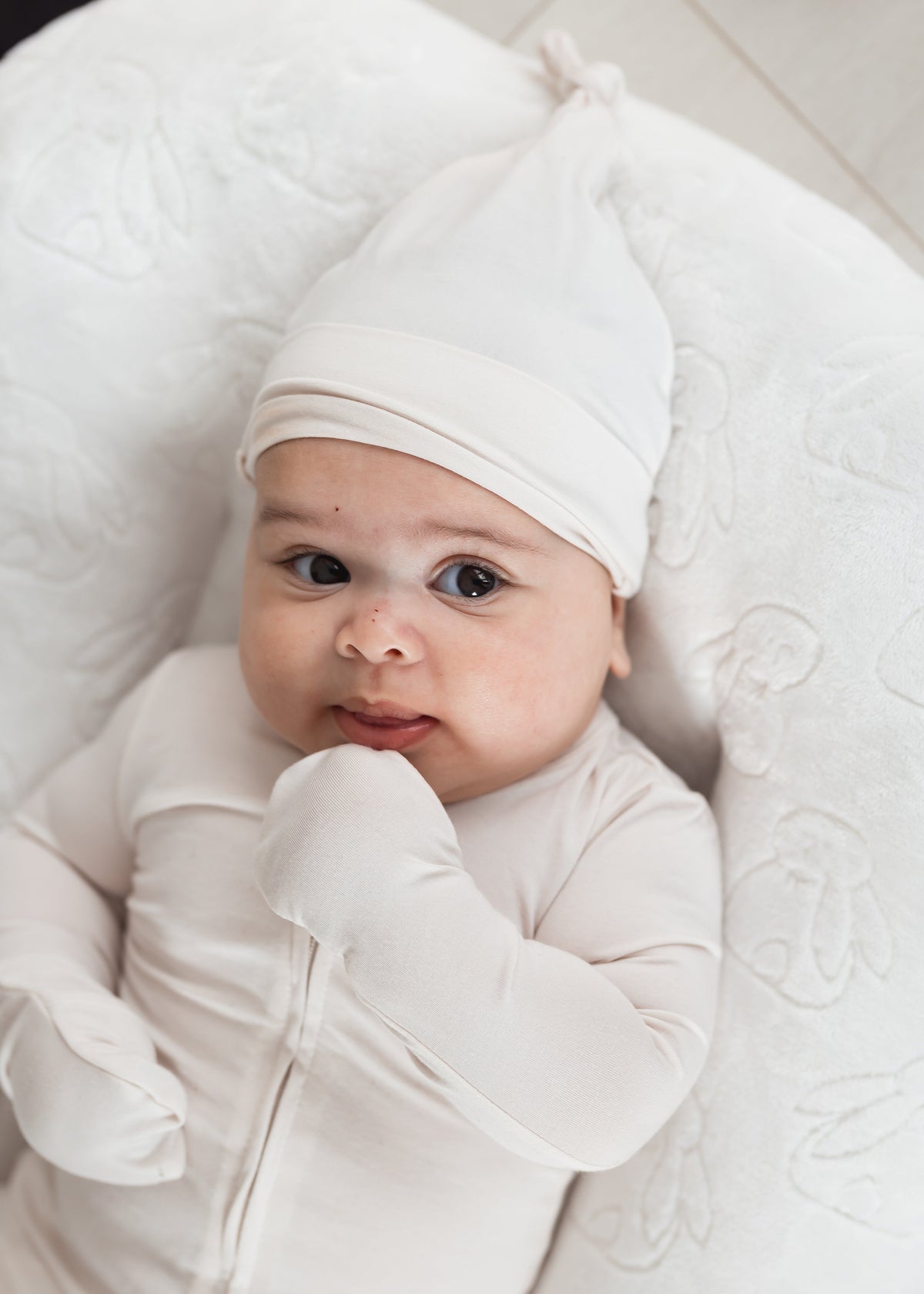 Baby in a lounger wearing a Milana Soft TENCEL sleeper with matching knot hat in the colour Birch.