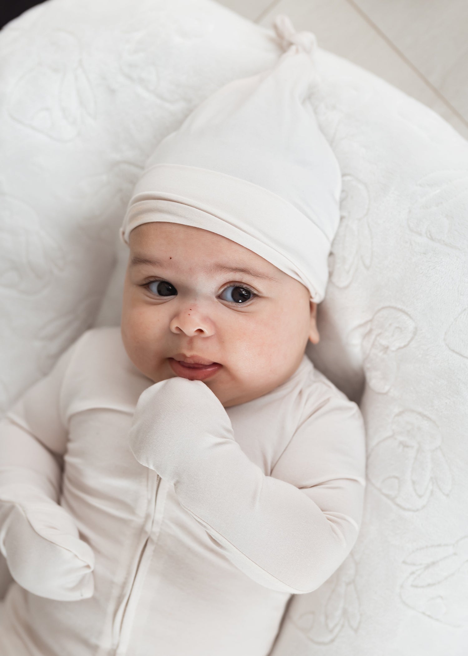 Baby in a lounger wearing a Milana Soft TENCEL sleeper with matching knot hat in the colour Birch.