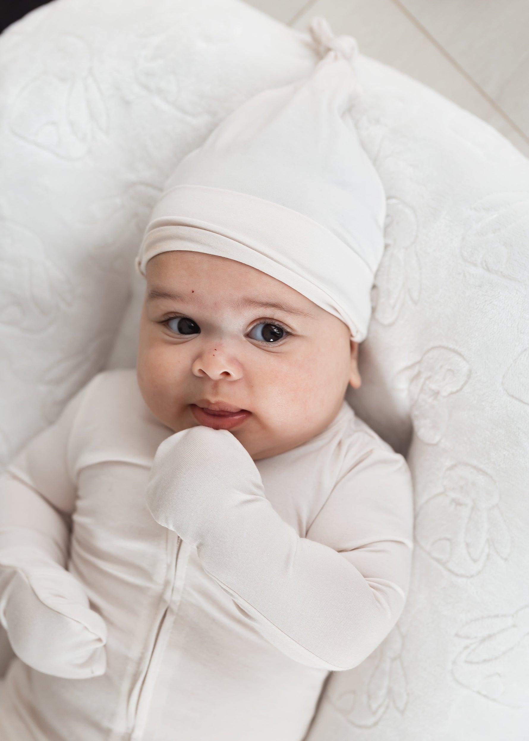 Baby in a lounger wearing a Milana Soft TENCEL sleeper with matching knot hat in the colour Birch.