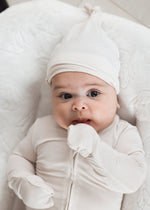 Baby wearing a Milana Label sleeper with matching knot hat while laying in a neutral lounger.