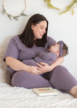 A mom and her daughter lounging in bed in their matching Milana PJ's in the colour Wild Mulberry.