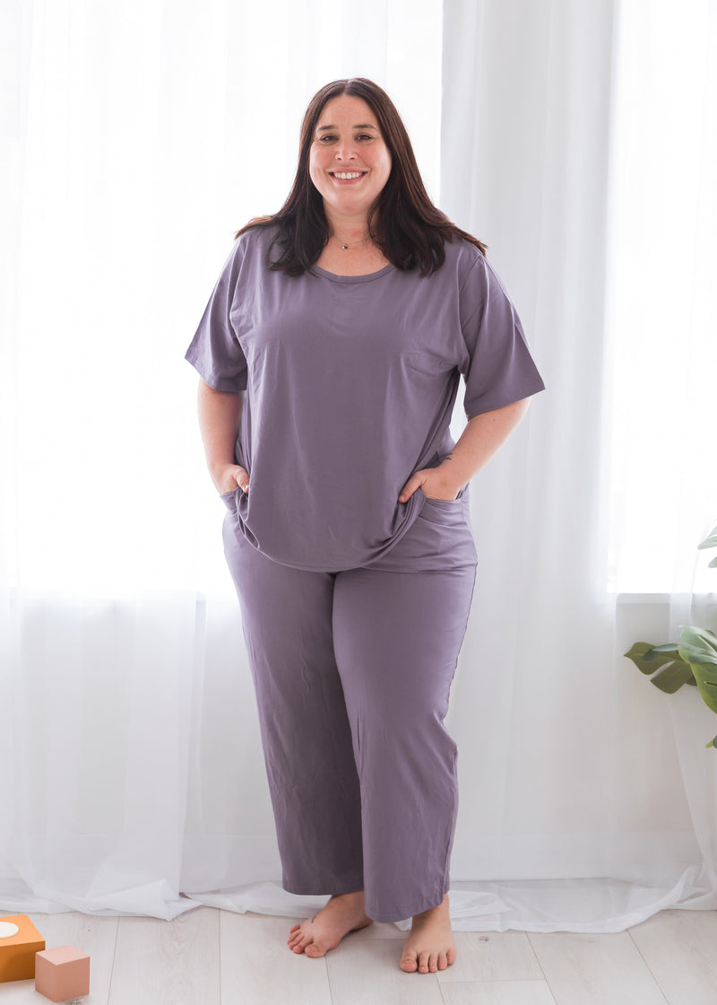 A woman modelling a Milana Label lounge set in the colour Wild Mulberry which is a dusty purple.