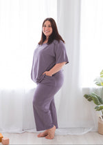 A woman wearing a Milana Label pyjama set crafted from buttery soft TENCEL fabric.
