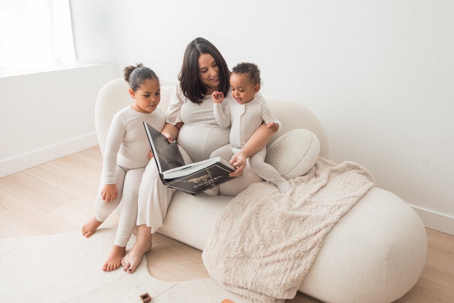 A mom reading to her two kids in their matching Milana Label pjs.