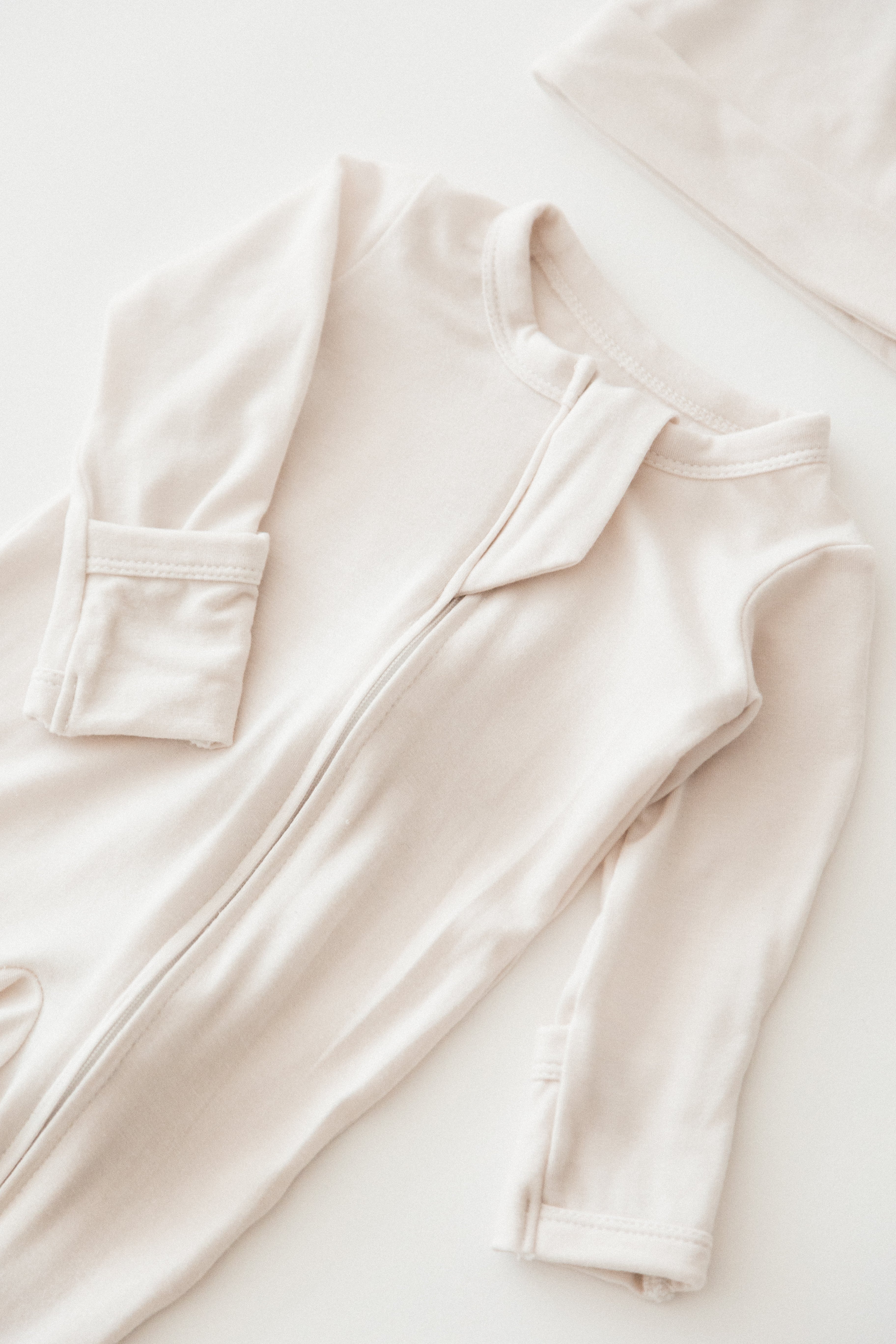 Close up of a neutral Milana Label sleeper with matching knot hat.