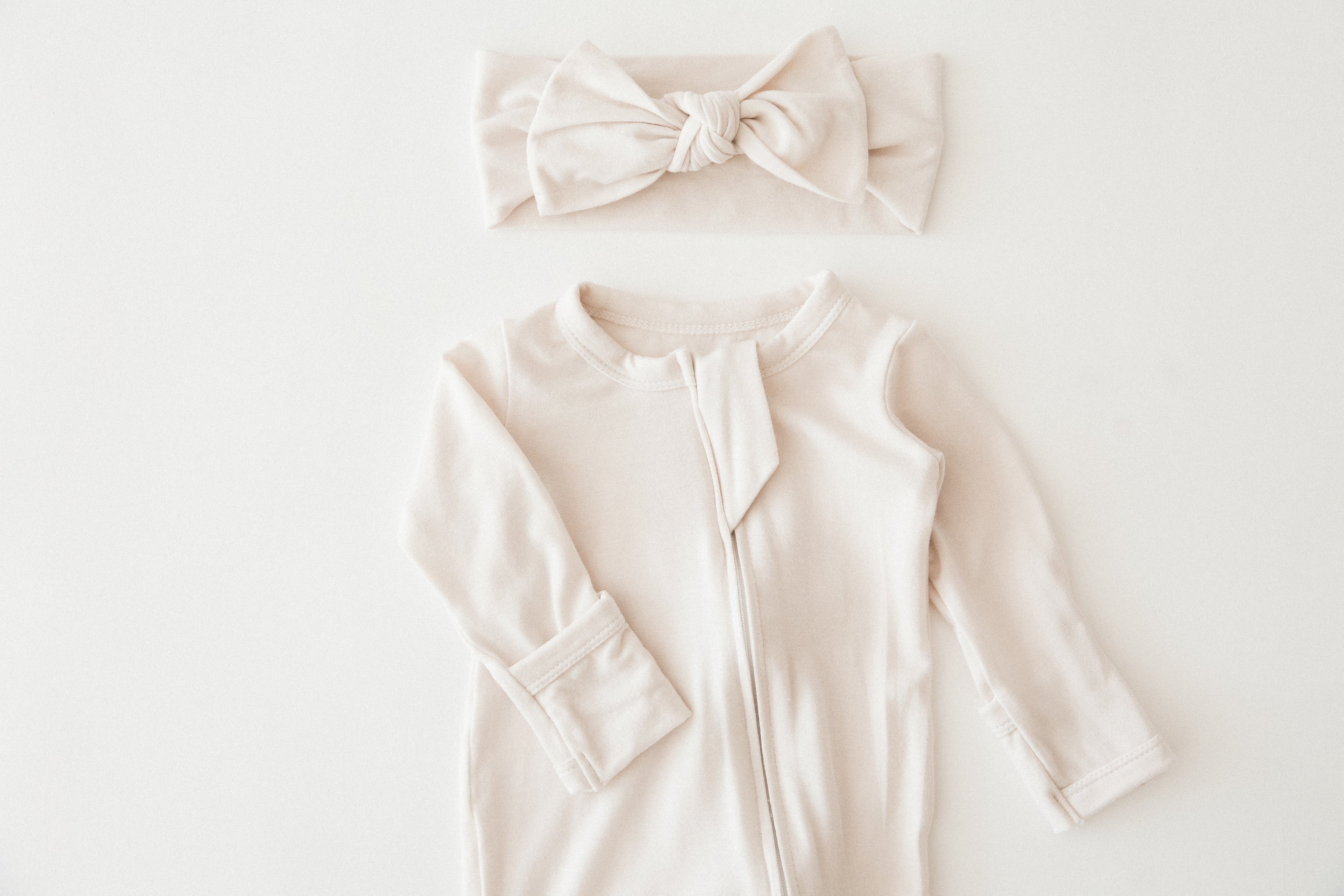 Milana Label baby romper and headband close up on a white background