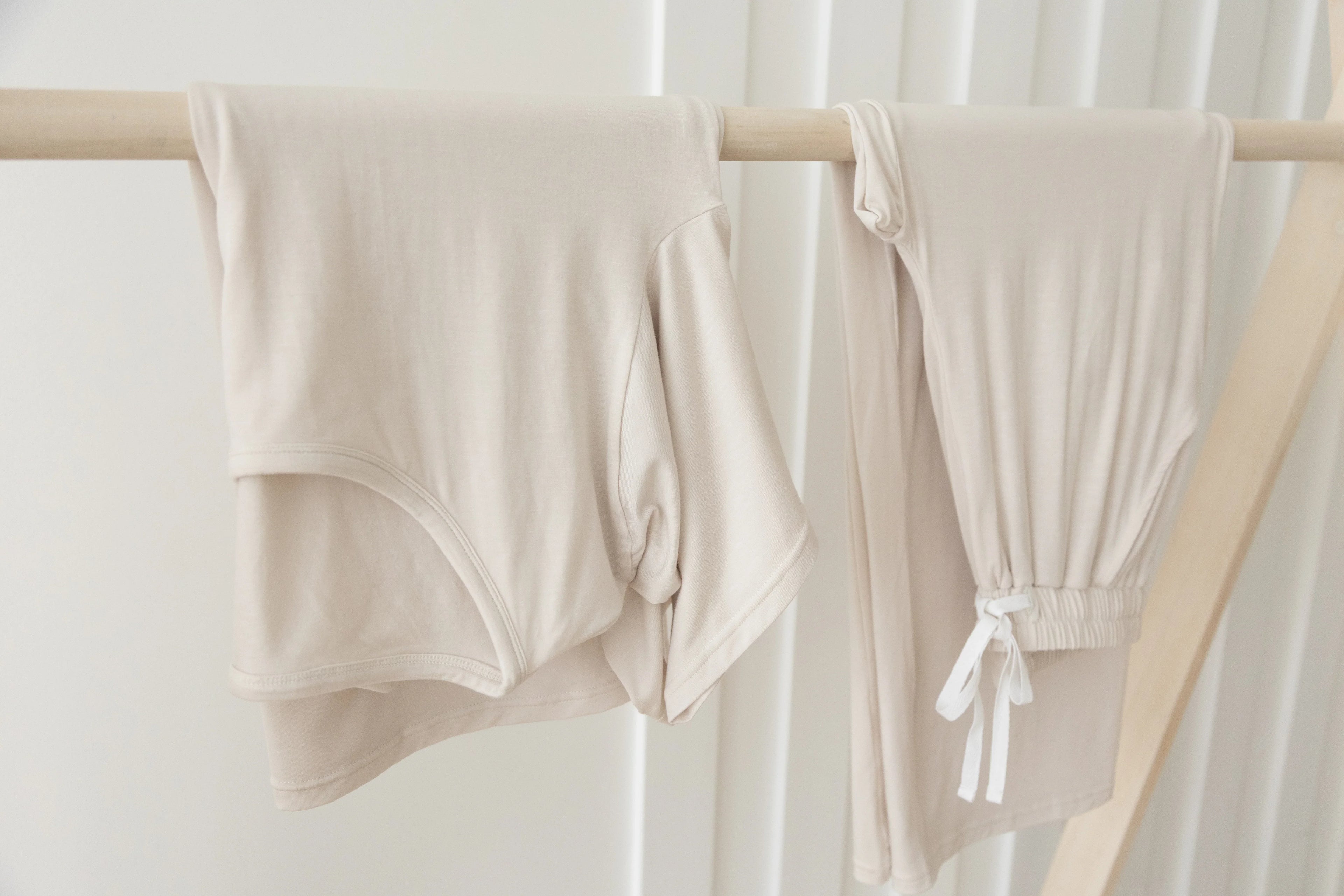Milana Label lounge set in a neutral colour hanging on a clothing rack.