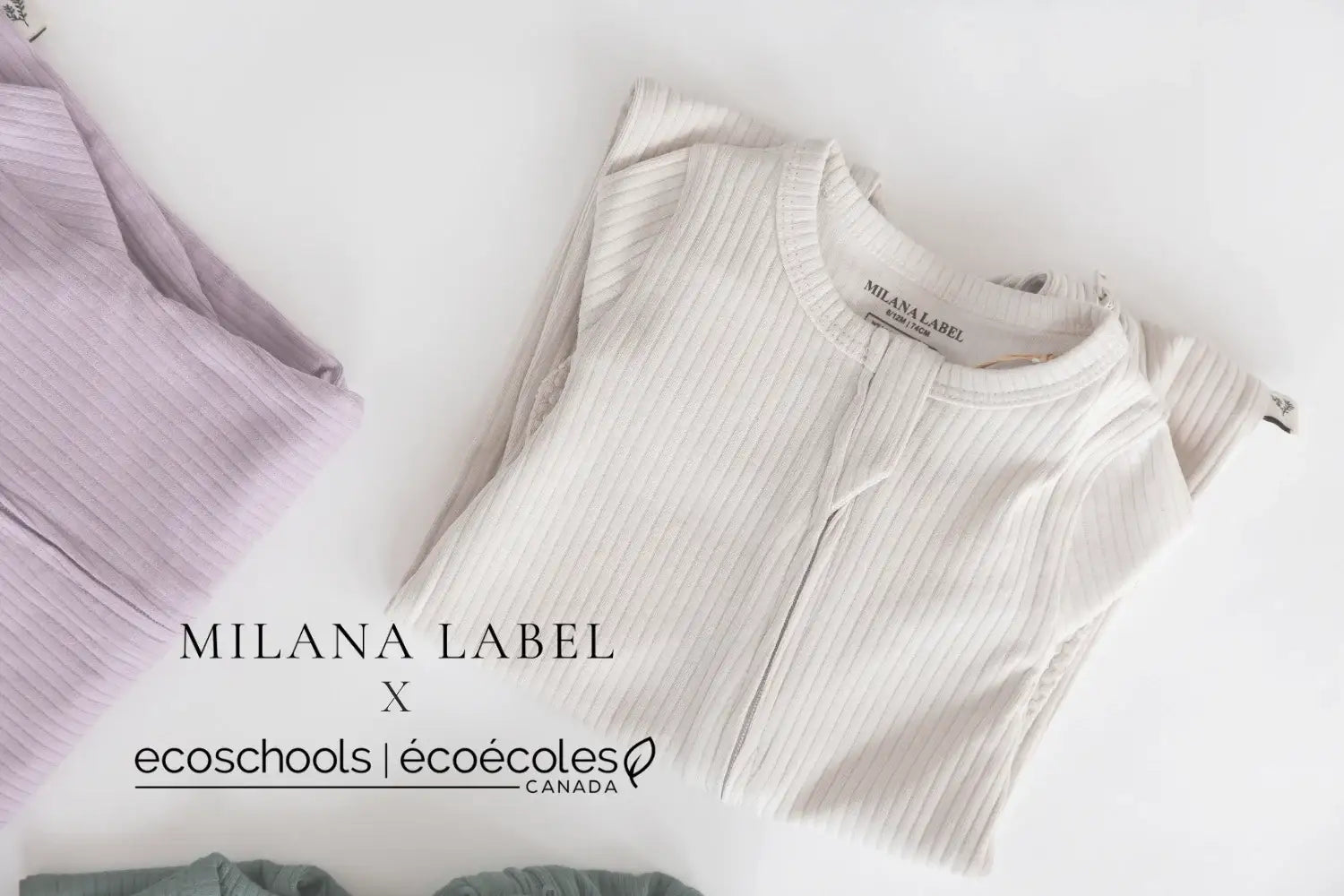 A folded organic cotton ribbed footie in the colour Stone, shown on a white background with a second footie partially visible on the left. Visible text includes 'MILANA LABEL' and 'ecoschools | écoécoles CANADA'.