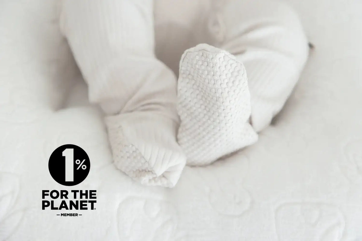 Close-up of a baby wearing white footed pajamas.