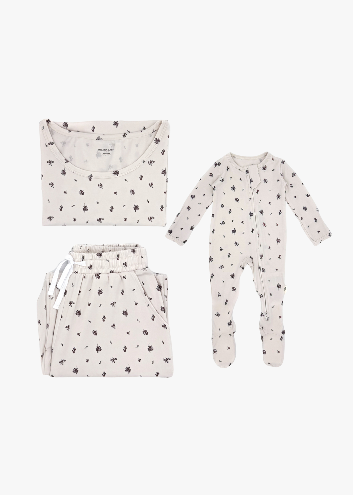 Milana Label mommy and me sleeper bundle in Birch, adult two-piece lounge set and baby zip footie sleeper laid flat together.