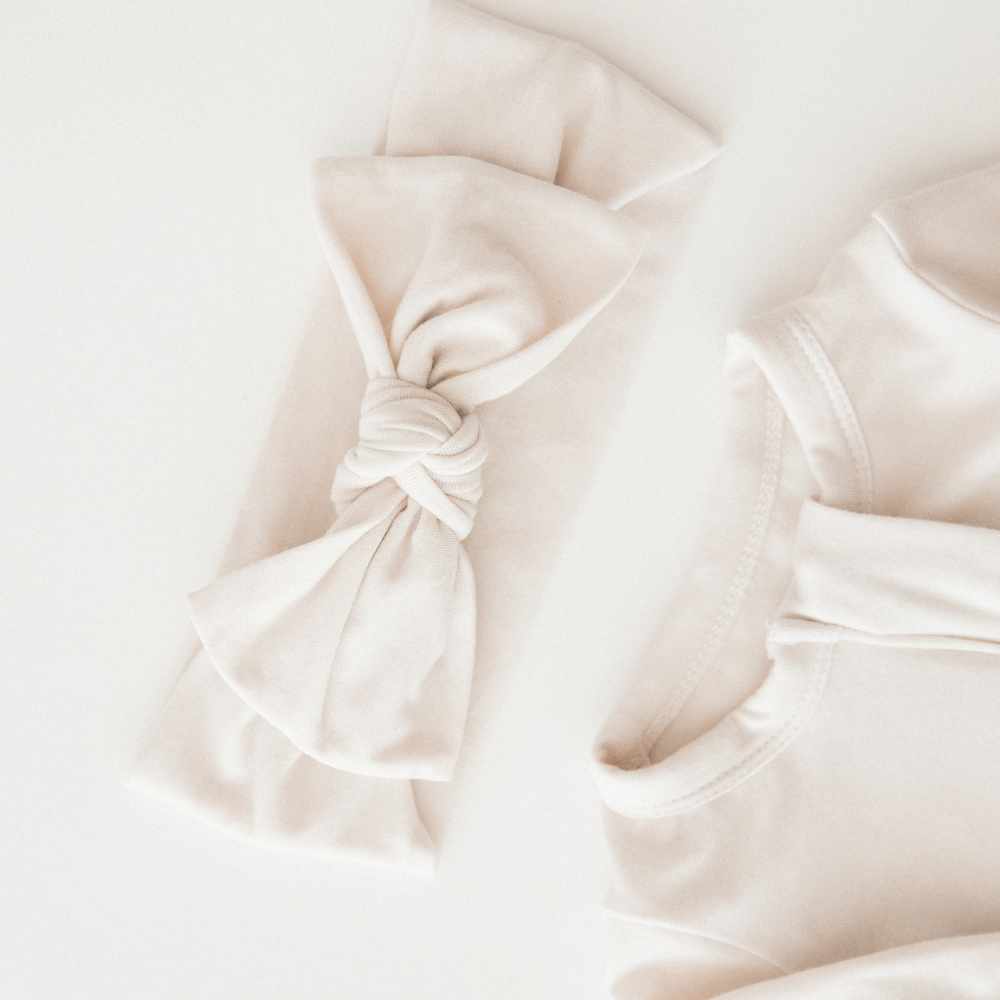 Close up of a neutral Milana Label sleeper with matching headband.