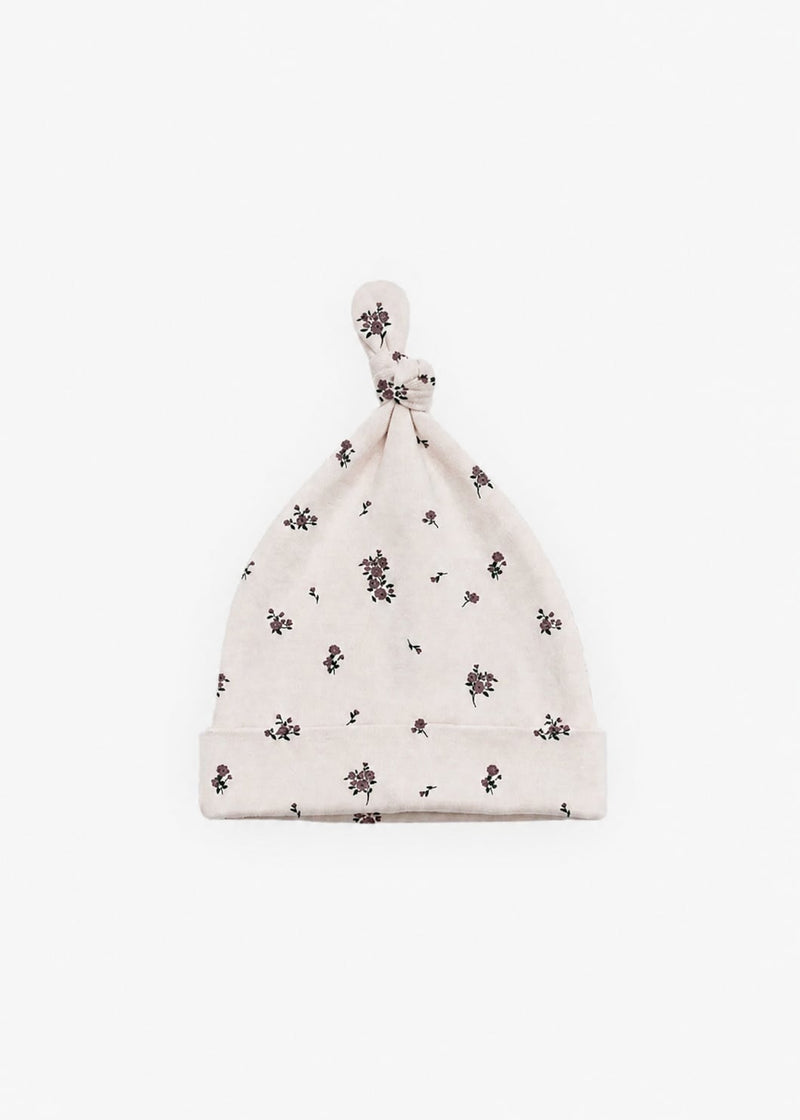 Milana Label knotted baby hat in Birch Floral, a warm cream fabric with a scattered dark floral print, photographed flat against a white background.