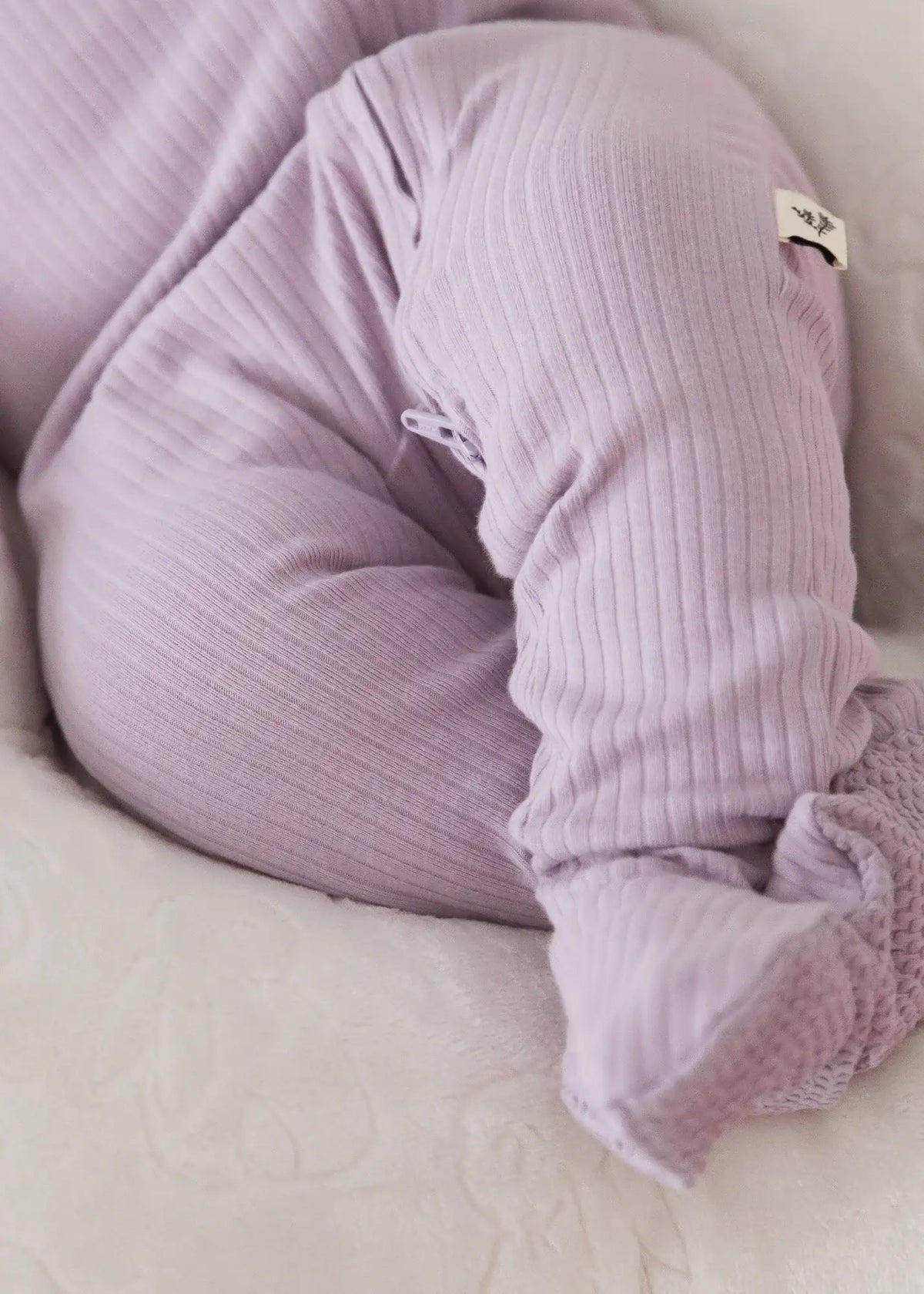 A close-up of the ribbed texture on a Milana Label sleeper in the colour Lavender Blush.