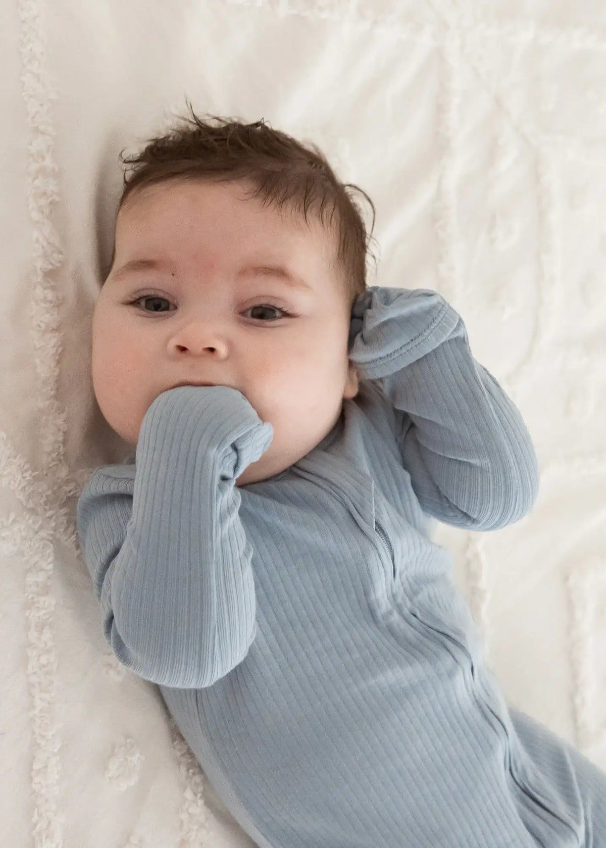 A close-up of the fold-over mitts feature on the zippered sleeper by Milana Label.