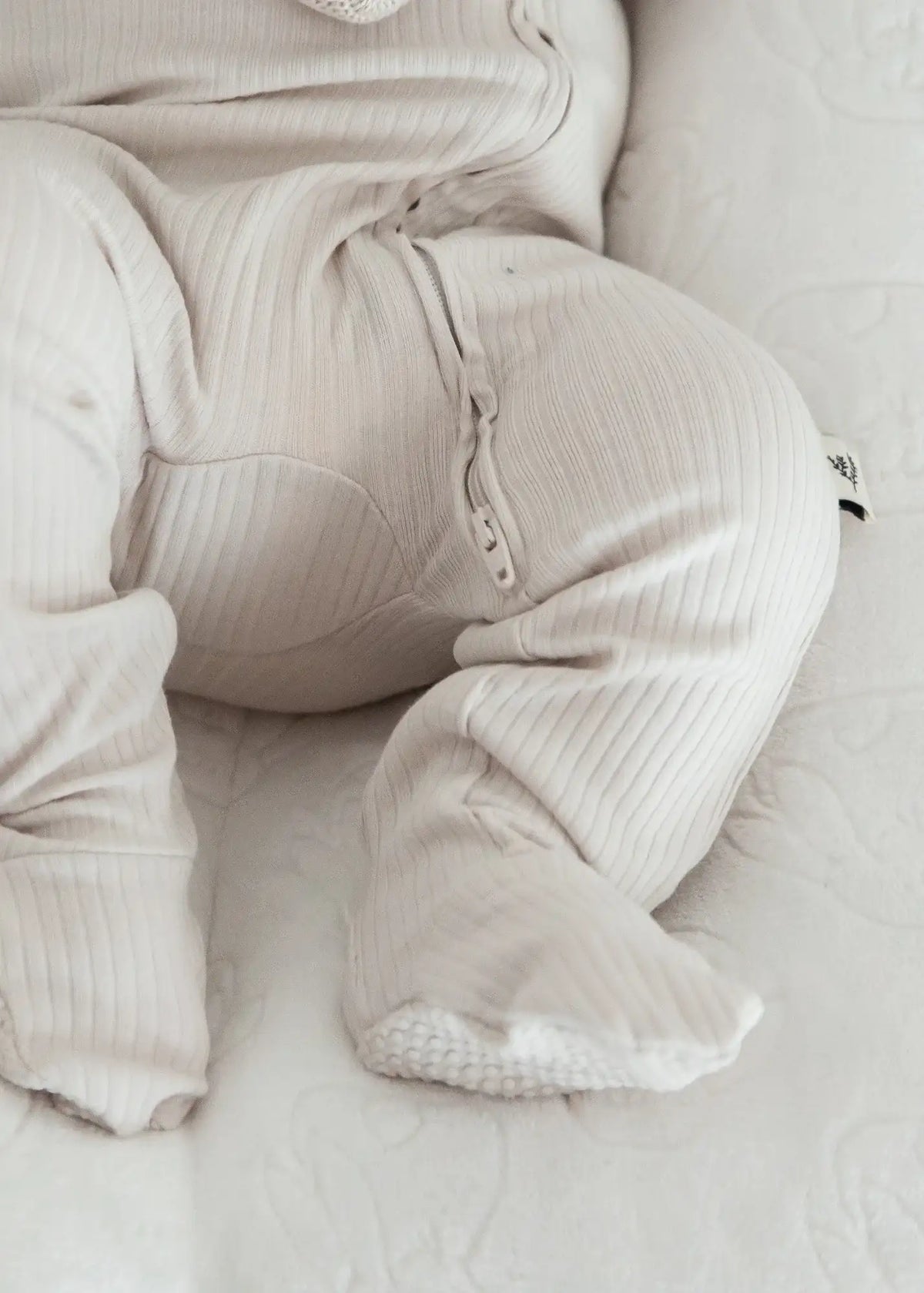 A close-up of the double zipper feature on the Stone ribbed zippered sleeper.
