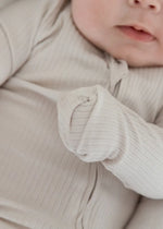A close-up of the ribbed texture on the Stone zippered sleeper by Milana Label.