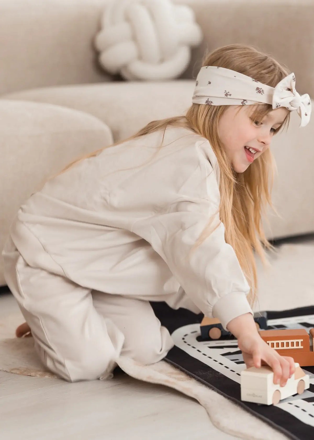 A girl playing on the floor in an oversized GOTS certified organic cotton matching two-piece set.