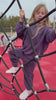 A child plays at the park in her Milana Label french terry jogger set in the colour Elderberry. The video showcases the durability behind the fabric.